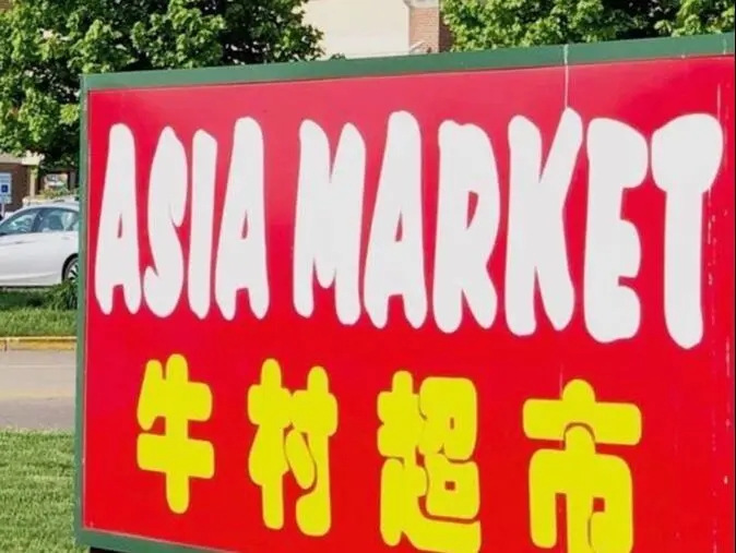 A sign for asian market in front of a building.