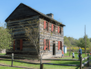 A cozy wooden house with charming red shutters that residents and visitors alike can enjoy.