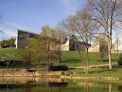 Back exterior of the Richard and Carole Cocks Art Museum sits a pond.