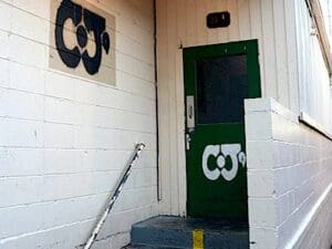 A green door with CJ's painted on in white letters