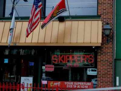 A sign for skippers club is on the front of a building.
