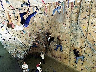 A group of people enjoy climbing on a climbing wall at one of Oxford's attractions.