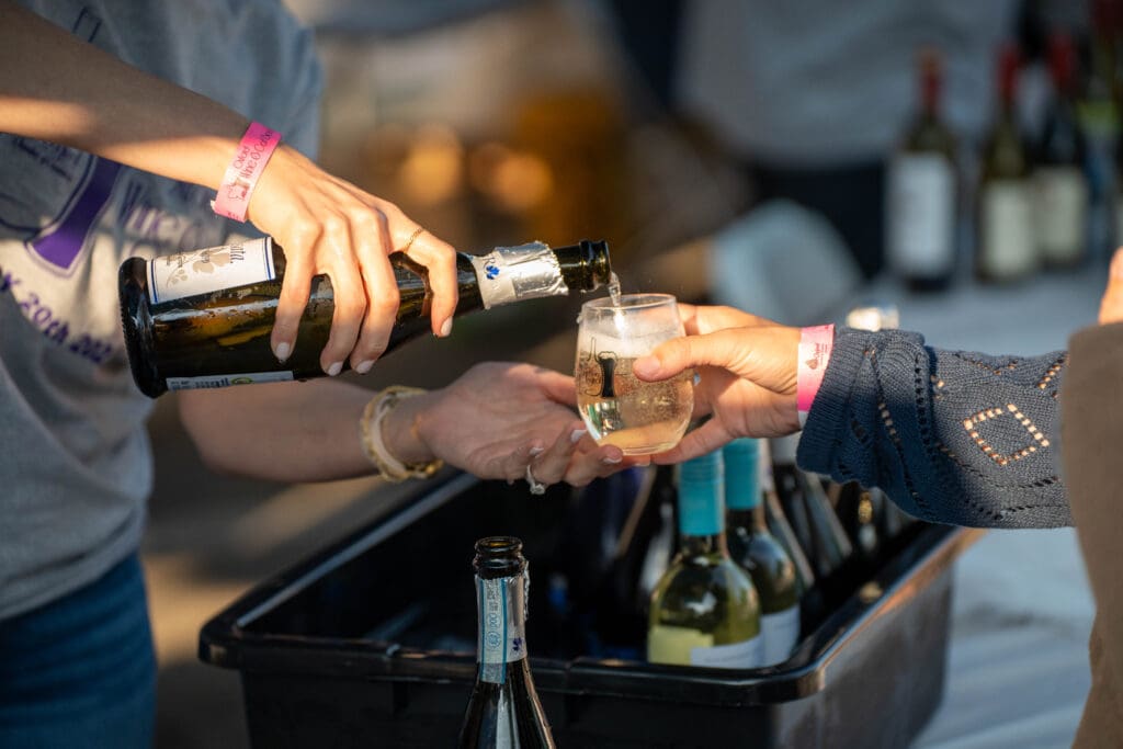 a close up of wine pouring into a tasting glass