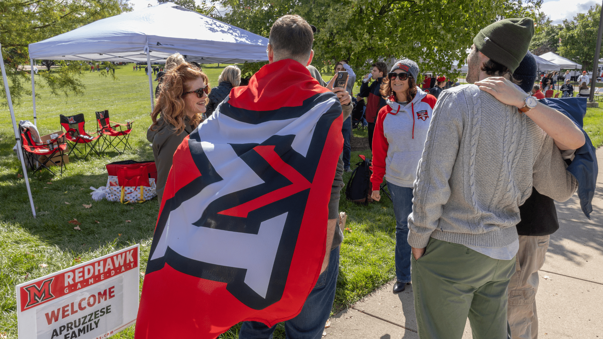 Student wears a Miami University beveled M flag as a cape