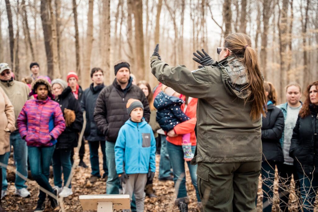 A group of people gathered around listening to a trail leader