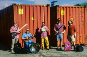 Posed photo of Queen City Silver Stars in front of shipping containers