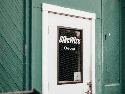 A white door with the word " bike wise " written on it.