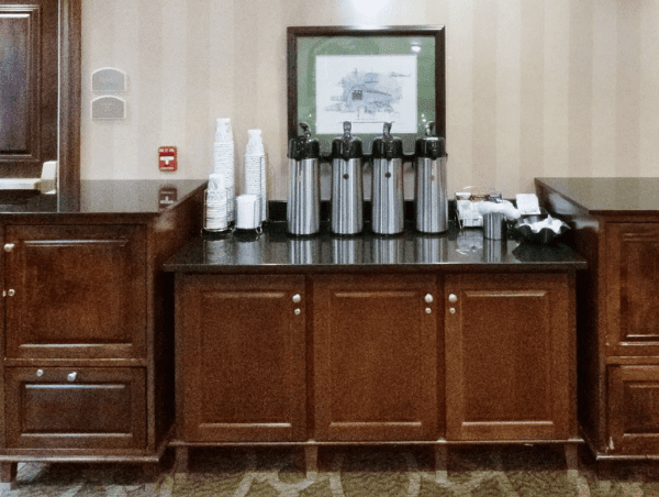 A room with many cabinets and some cups on the counter