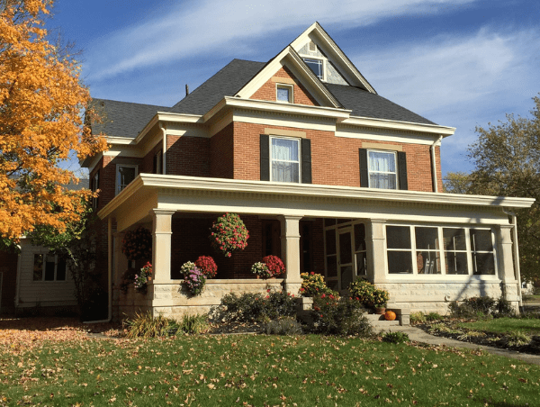 A large house with flowers in the front yard.