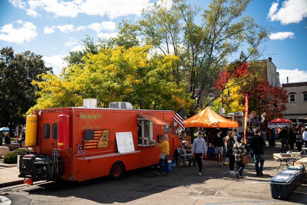 A food truck parked in front of a crowd.