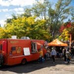 A food truck parked in front of a crowd.