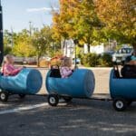 Three children are riding in a toy train.
