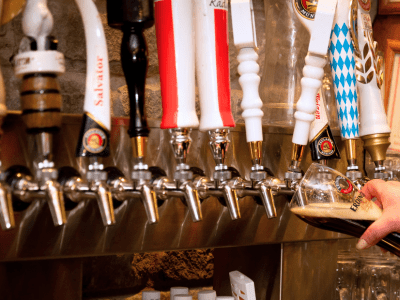 A row of beer taps in front of a wall.