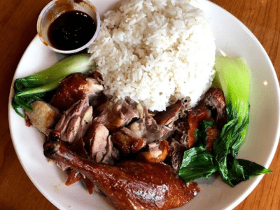 A plate of food with rice, meat and vegetables.
