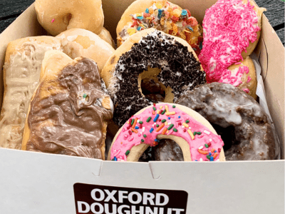 A box of assorted doughnuts with different flavors.