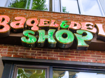 A sign that says " bagel & deli shop ".
