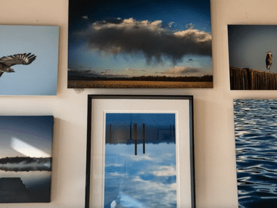 A wall with several pictures of clouds and sky.