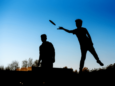 Two men playing frisbee in the park.