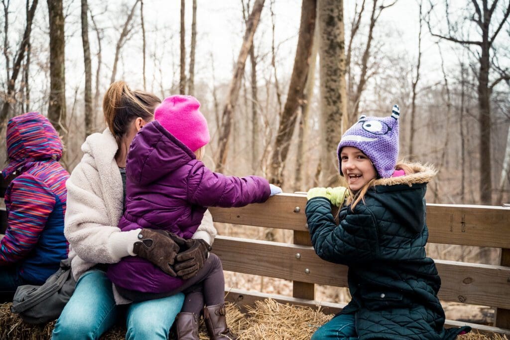 A group of people sitting on top of a wooden bench.