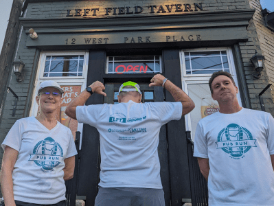 Group posing of three in front of Left Field Tavern in Pub Run T-shirts