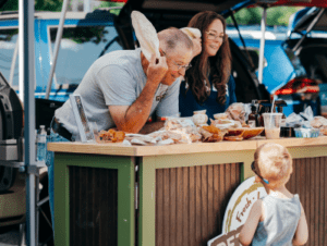 Man leaning over booth to talk to a little boy