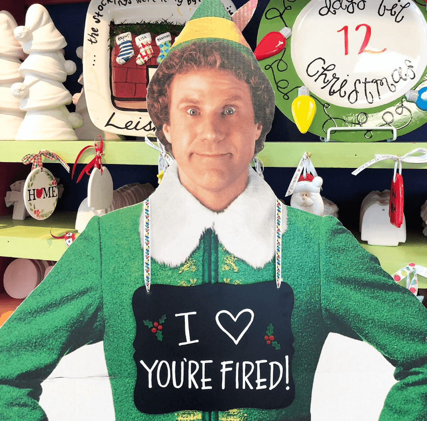 Buddy the Elf cutout wearing a I heart You're Fired sign around his neck