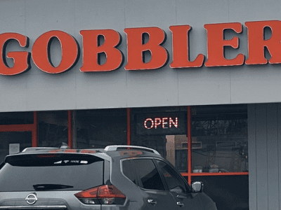Gobbler sign in orange text outside of grey building