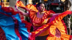 Woman dancing in a traditional hispanic bright orange dress