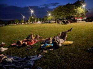 a couple of people laying down looking at the night sky at the Oxford Community Park