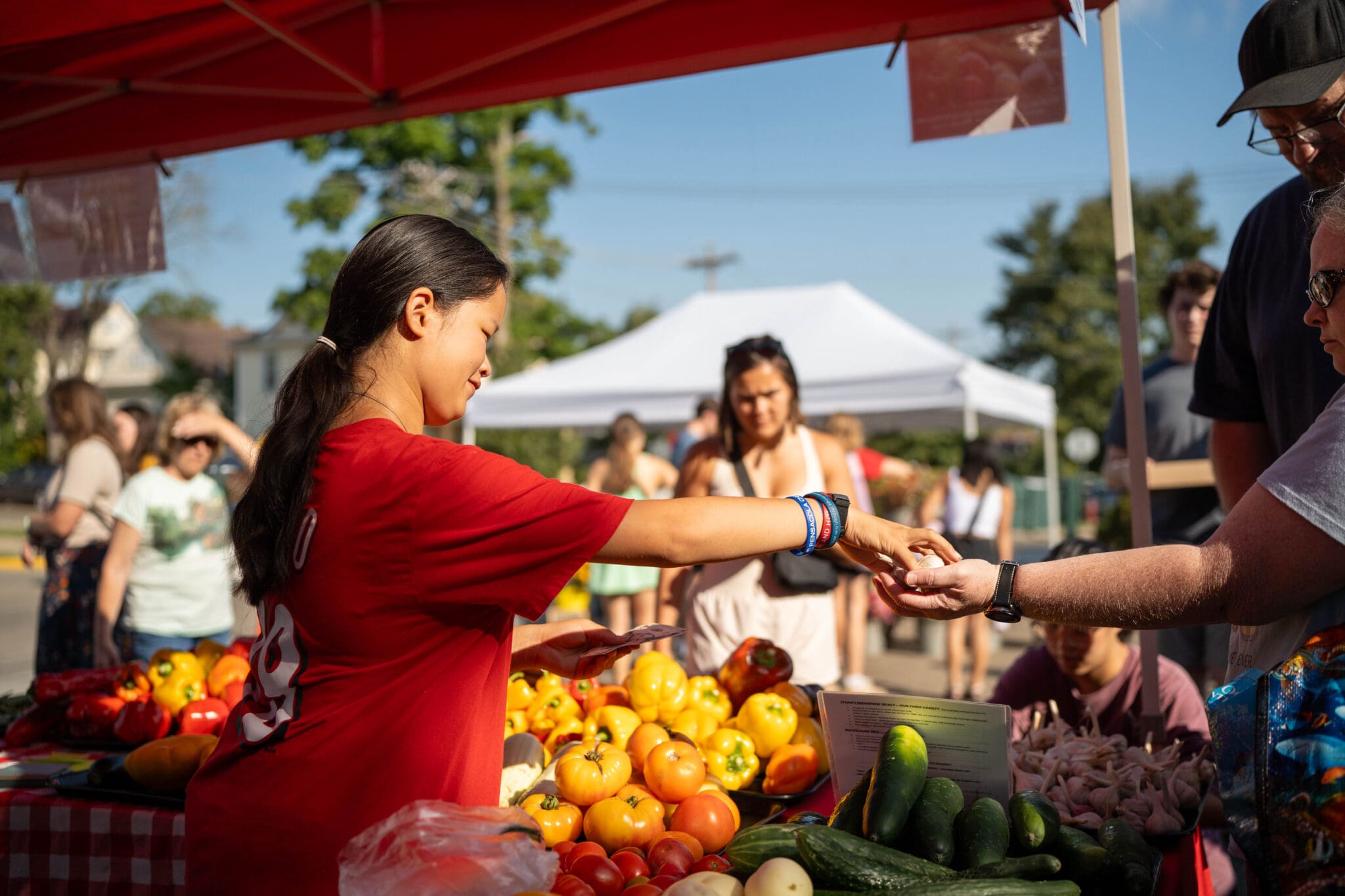 Woman buying produce at a market stall.