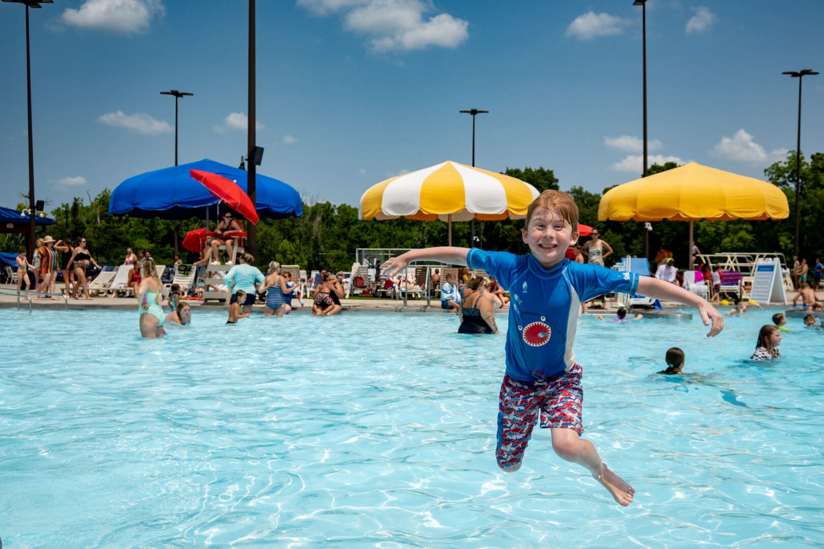 Photo of a happy kid jumping into the Oxford Aquatic Center pool.