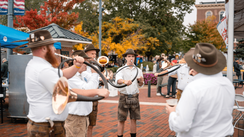 Men in lederhosen playing alphorn.