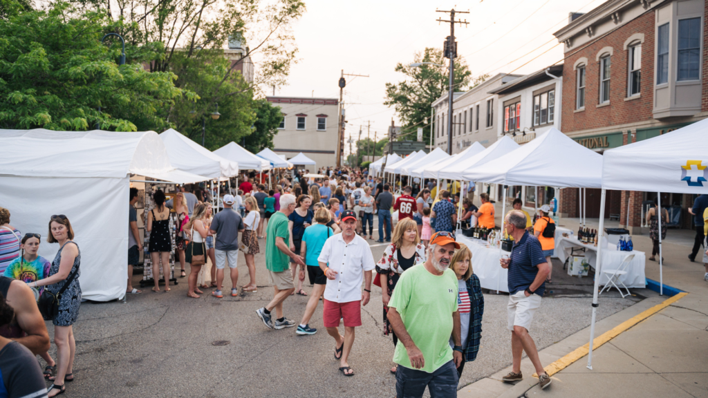 Busy street fair with many vendors.