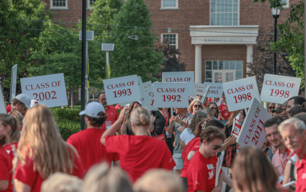 Miami University alumni gathered with class signs