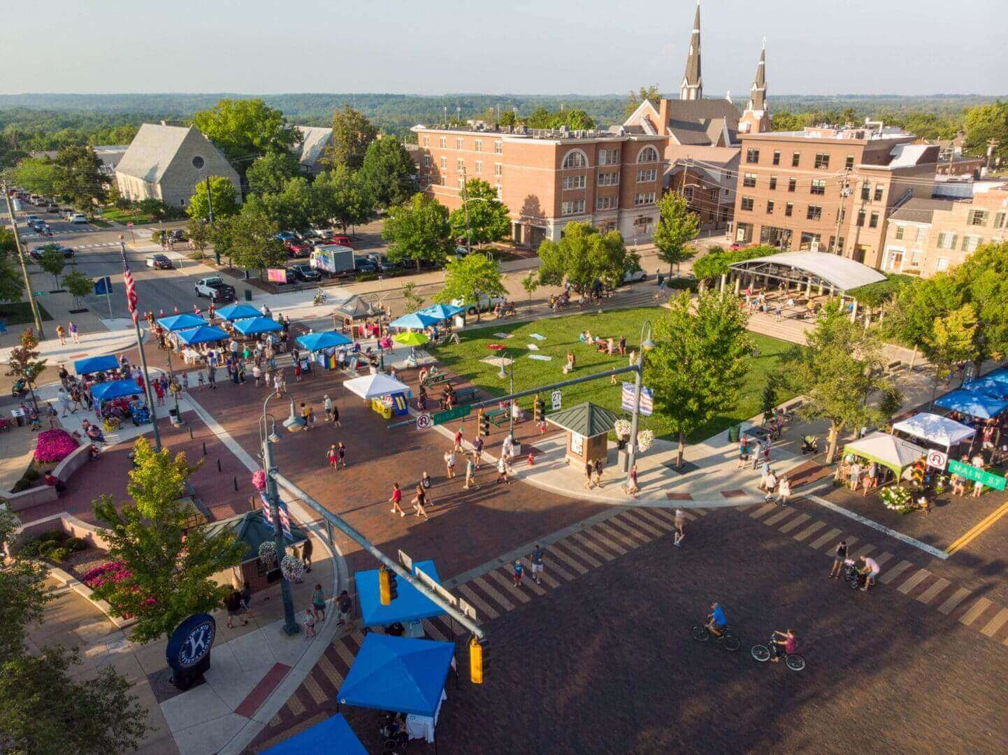 Aerial view of a town square with vendors and people.