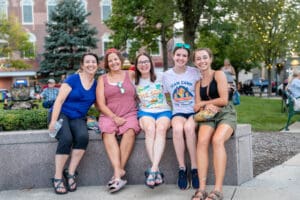 5 people sitting and smiling together