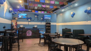 Inside Esencia Latina you'll find blue and white painted walls, Latin American decor, and tabled seating.