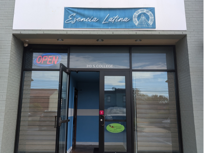 Exterior of Restaurante Esencia Latina with a blue sign above the door.