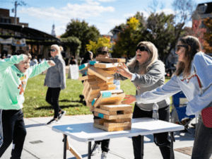 A family playing a game of giant Jenga as the bricks begin to fall at Oxford Memorial Park