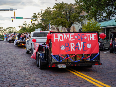 Parade truck with sign that says "Home of the Brave"