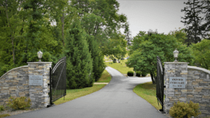 Cemetery entrance with stone pillars and steel gate.