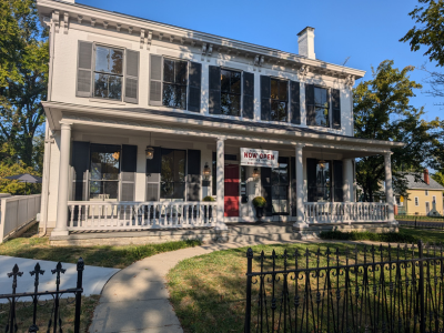 Exterior photo of the historical Alexander House with black iron fence. Now known as RedLife Coffee.