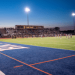 Football field with players and a crowd.