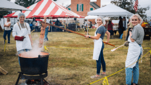 Three volunteer cooking apple butter at the Apple Butter Festival