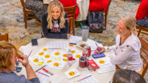 A group of people sitting at a table of worksheets.