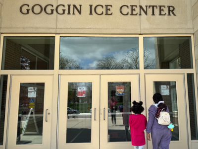 Two people walking into the Goggin Ice Center