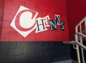 Red concrete wall with cutout letters spelling "Chanks" on top