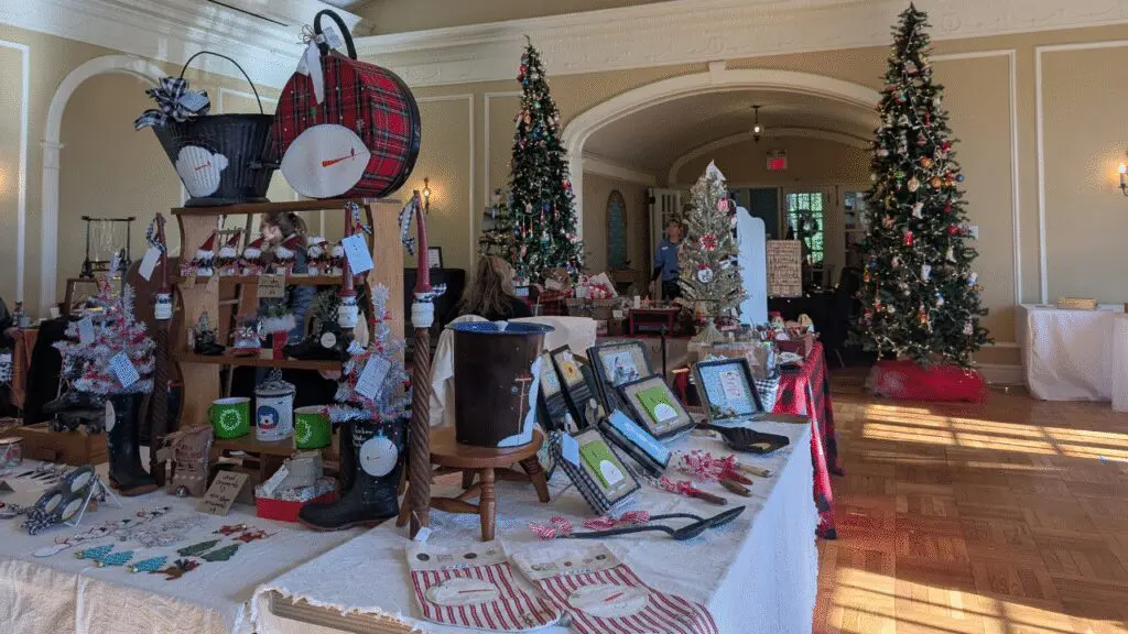 A table set up with holiday gifts and trinkets in a large ballroom