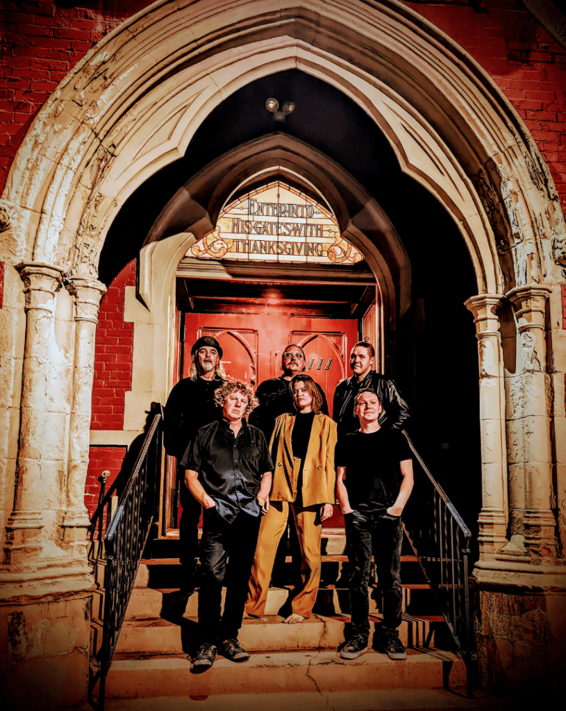 Portrait photo of King Bee & The Stingers band in front of old chapel doors