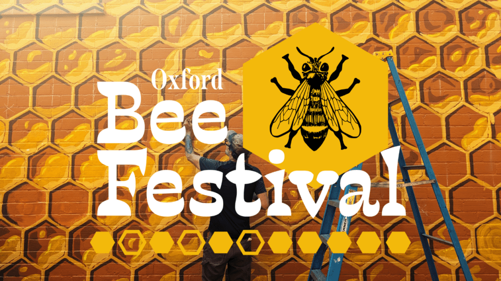 Oxford Bee Festival logo in front of "The Oxford Hive" mural